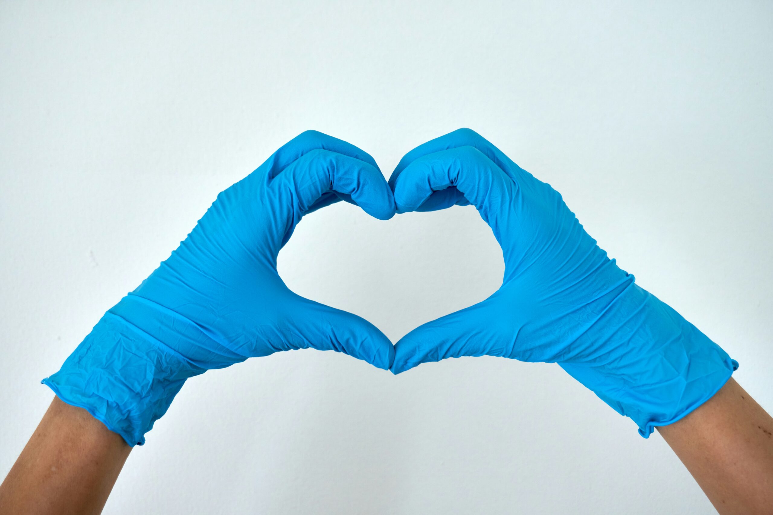 Gloved hands making a heart shape